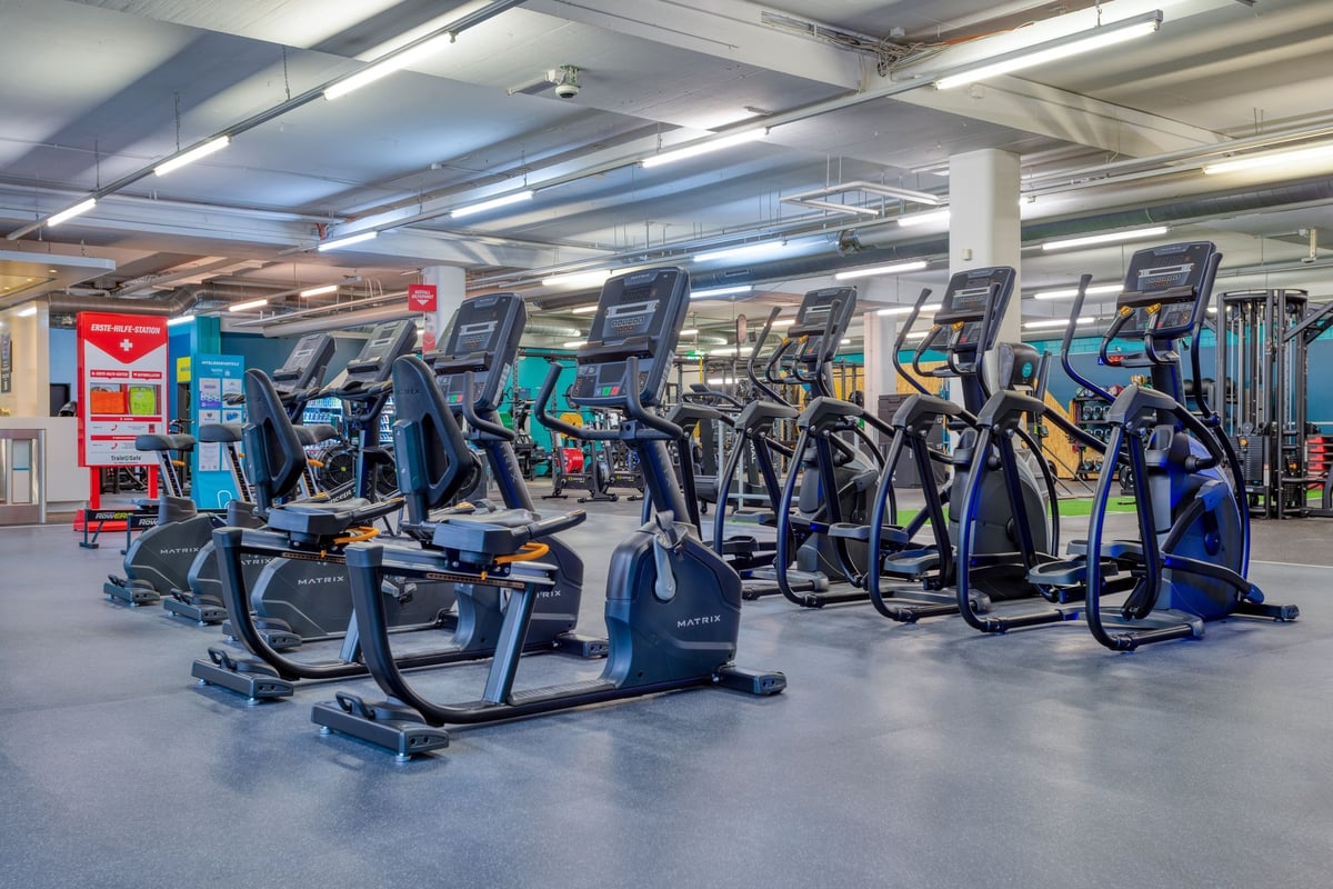 PureGym Dübendorf: Rows of cardio machines and exercise bikes in a gym cardio area.