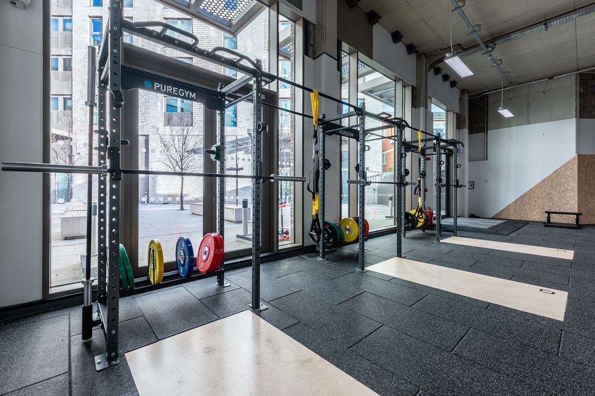 PureGym London Seven Sisters: Gym interior with squat racks, weight plates in vivid colours, rubberized flooring strips.