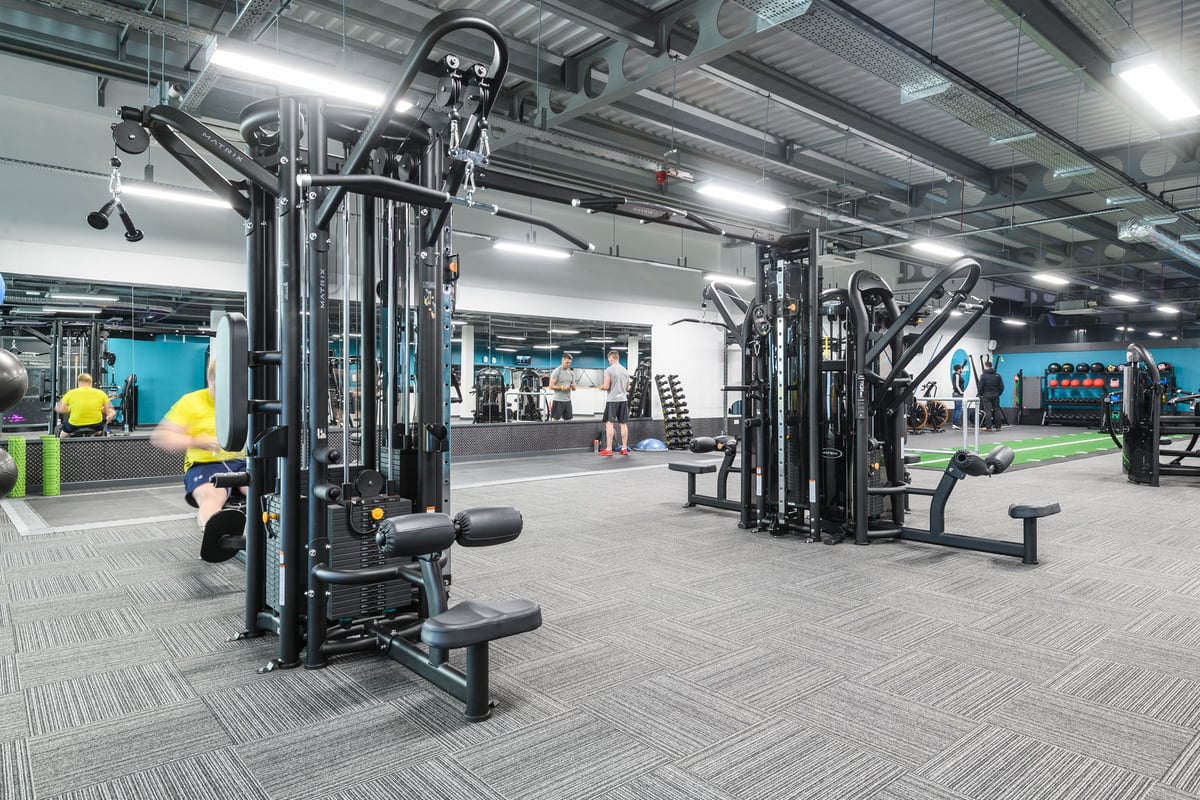 PureGym Leeds Thorpe Park: Gym floor with resistance machines, free weights, benches, and rubberized flooring.