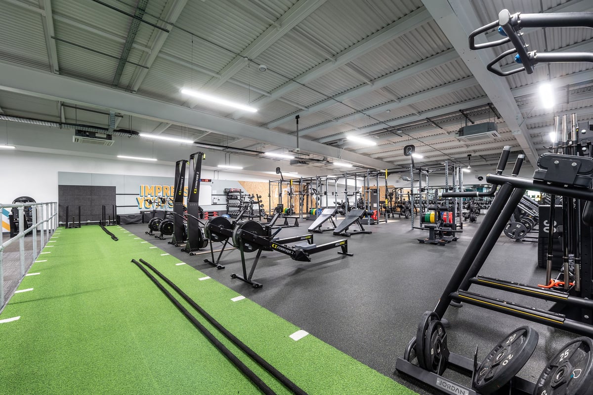PureGym Manchester Cheetham Hill Retail Park: Gym with weight machines, free weights, turf area, and rubberized floors.