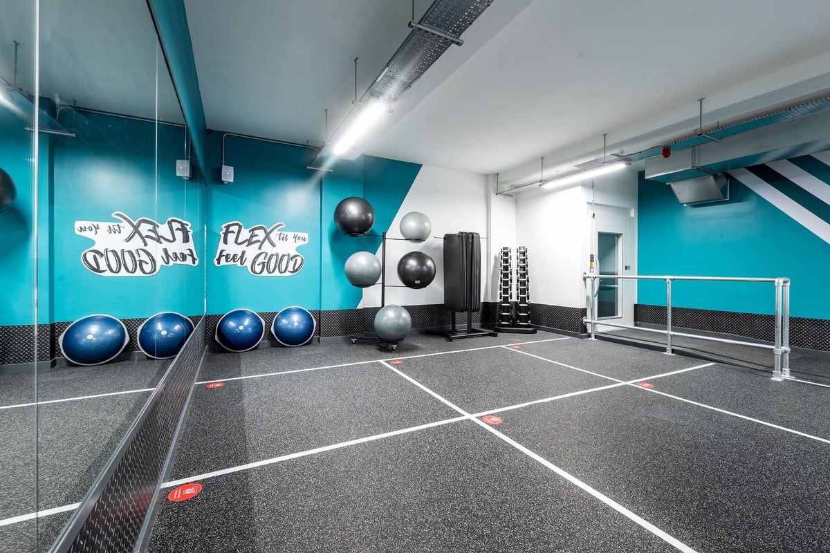 PureGym London Holloway Road: Exercise balls, wall graphics, free weights, and rubberized flooring in a gym studio.