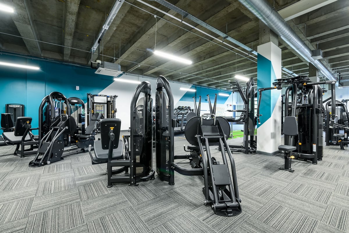 PureGym London Wimbledon: Resistance training machines, weight racks, rubberized flooring in an industrial-style gym.
