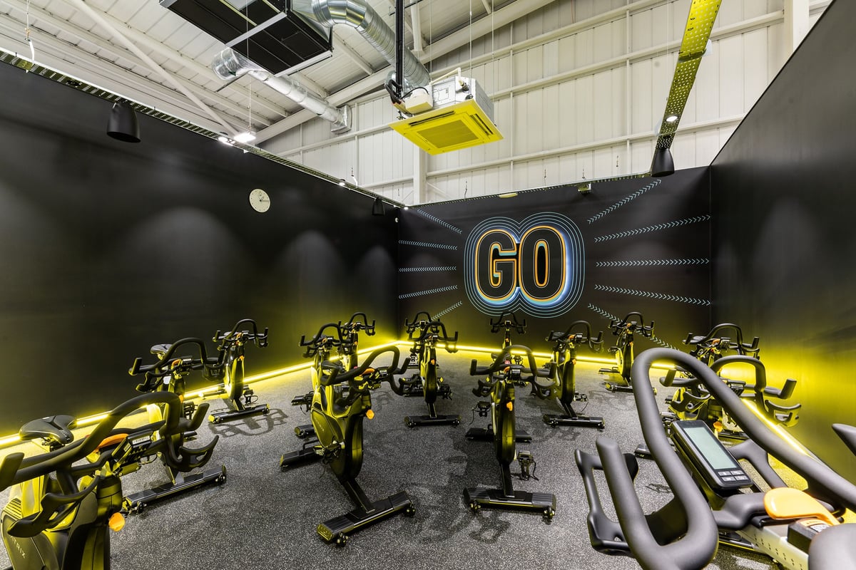 PureGym Eastbourne: Resistance machines in yellow and black, rubberized flooring, motivational 'GO' signage.