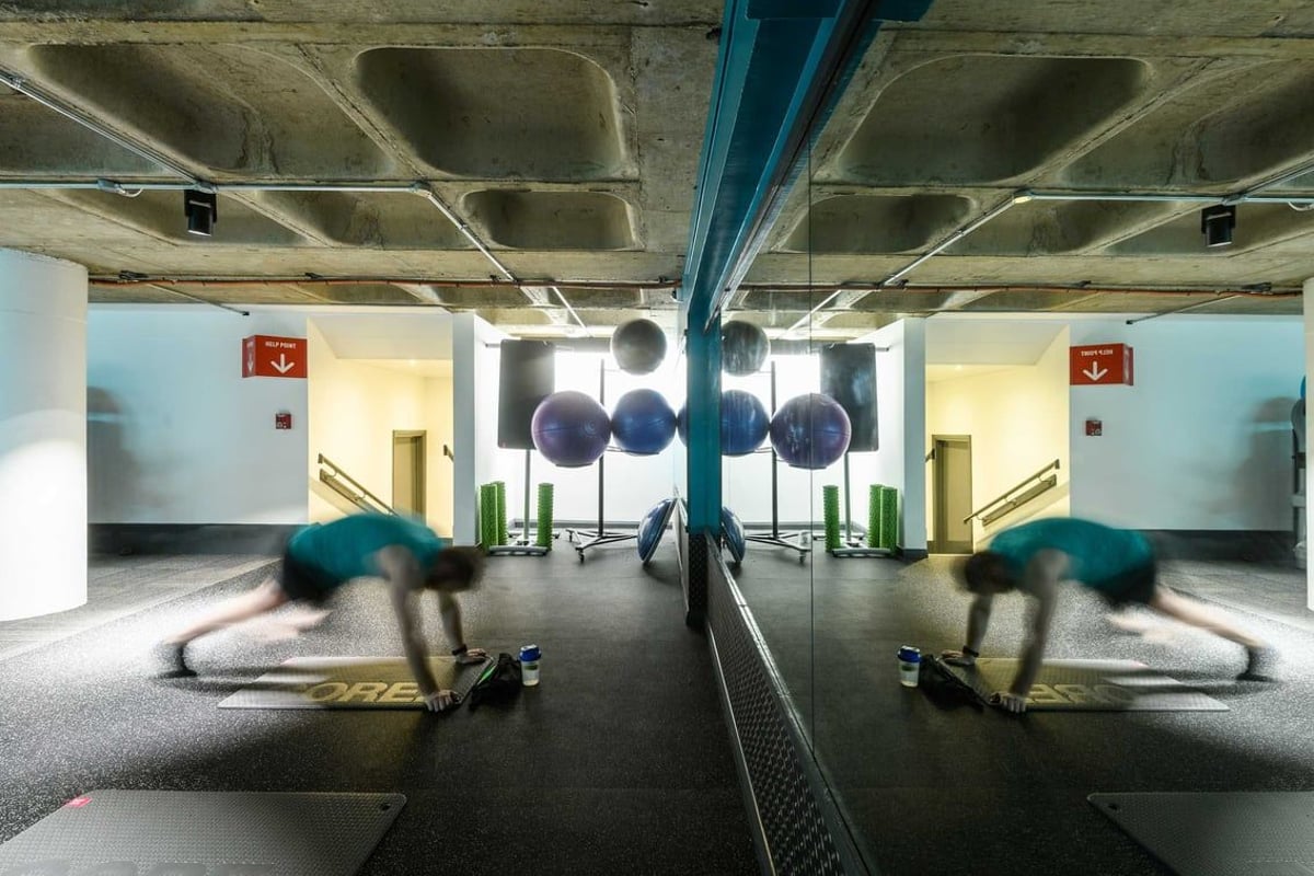 PureGym Farringdon: workout area with rubberised flooring and a mirror spanning the length of the wall