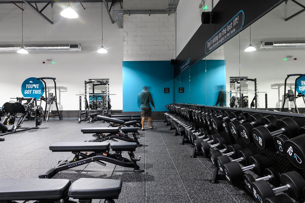 PureGym Northampton Weston Favell: Free weights, benches, resistance machines, and blue accent walls.
