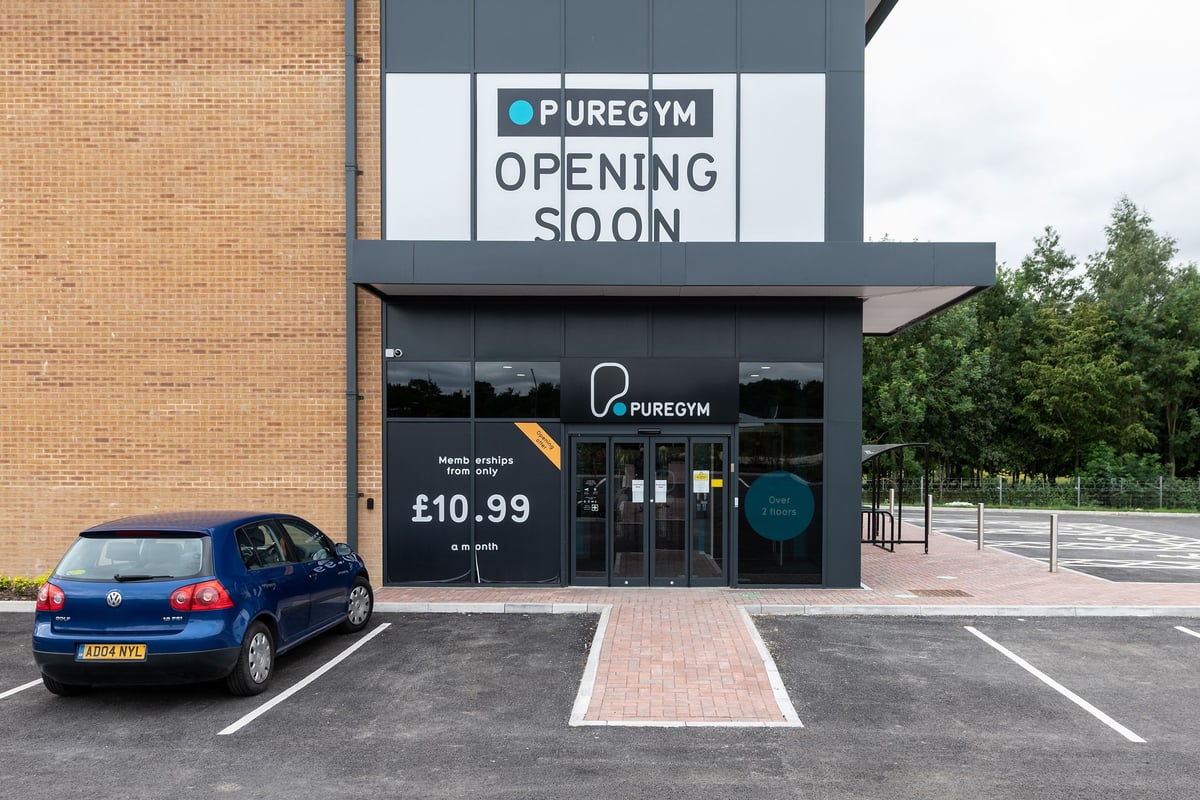 PureGym Andover: Exterior of gym with opening soon signage, vehicle parked outside.