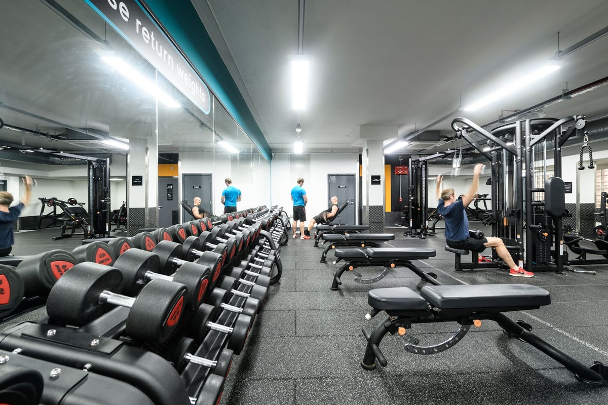 PureGym London St Pauls: Rows of treadmills, weight benches, dumbbells and other strength training equipment in a gym.