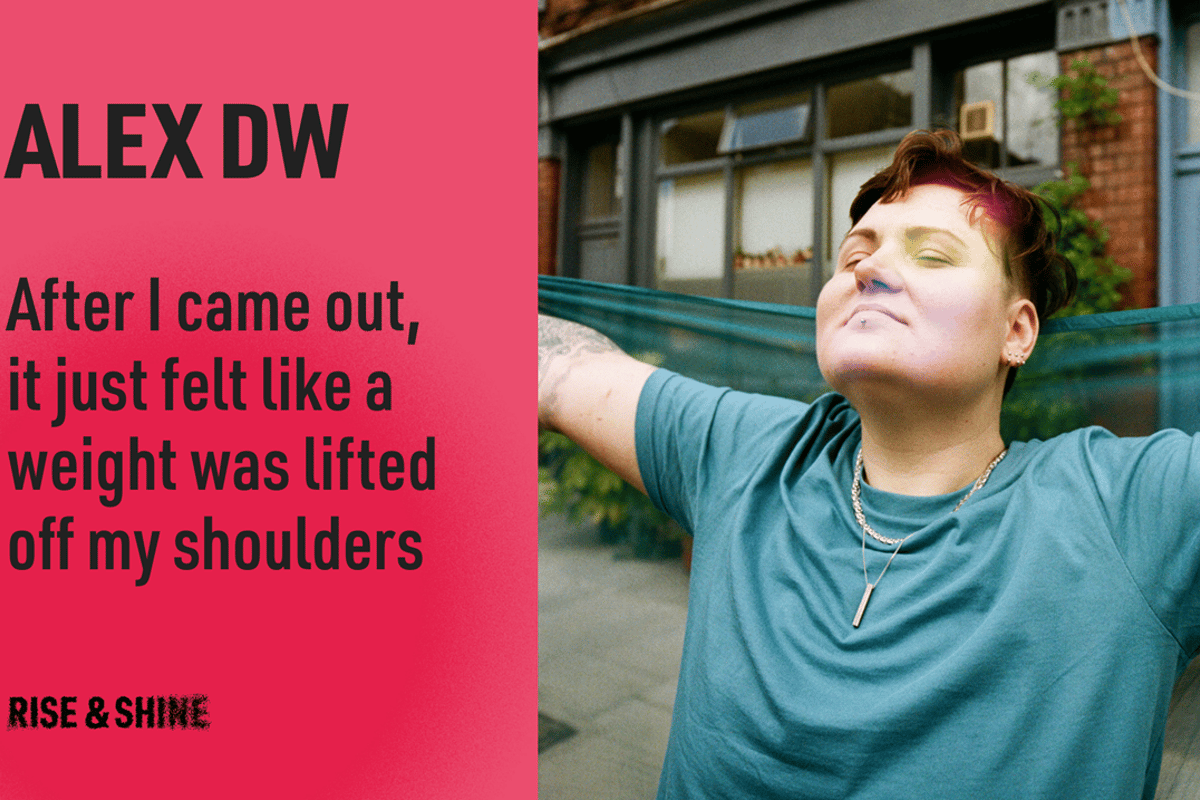 Person with short hair and piercings stretching arms outdoors with eyes closed