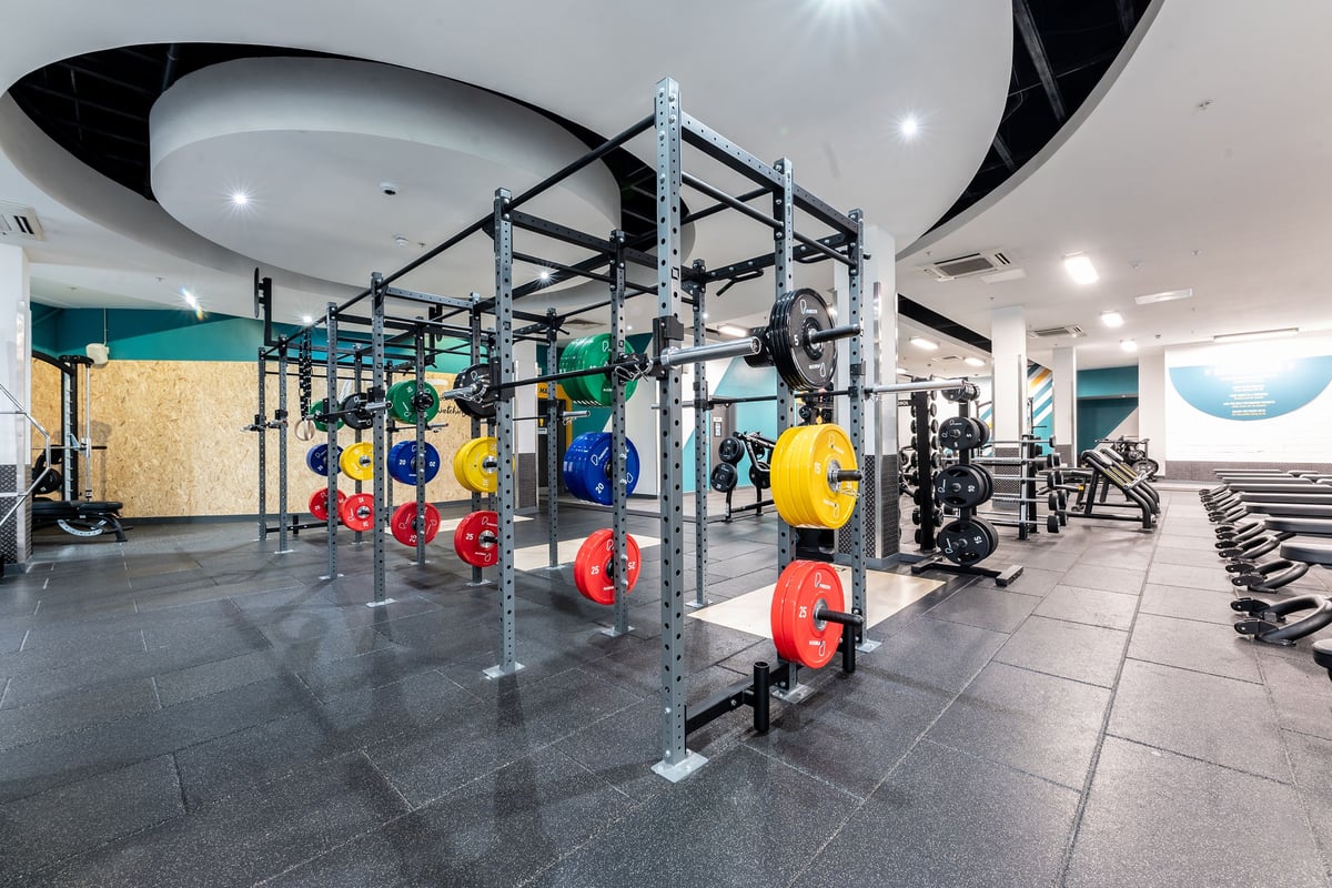 PureGym Newcastle Eldon Garden: Rigging frame with weight plates, medicine balls, free weights, and rubberized flooring.
