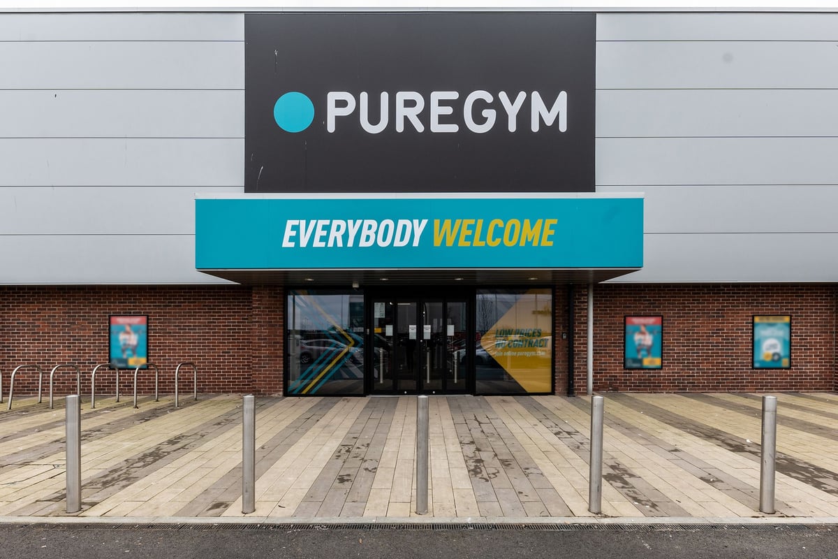 PureGym Eastbourne: Gym entrance with signage 'PUREGYM' and 'EVERYBODY WELCOME', bike racks outside.