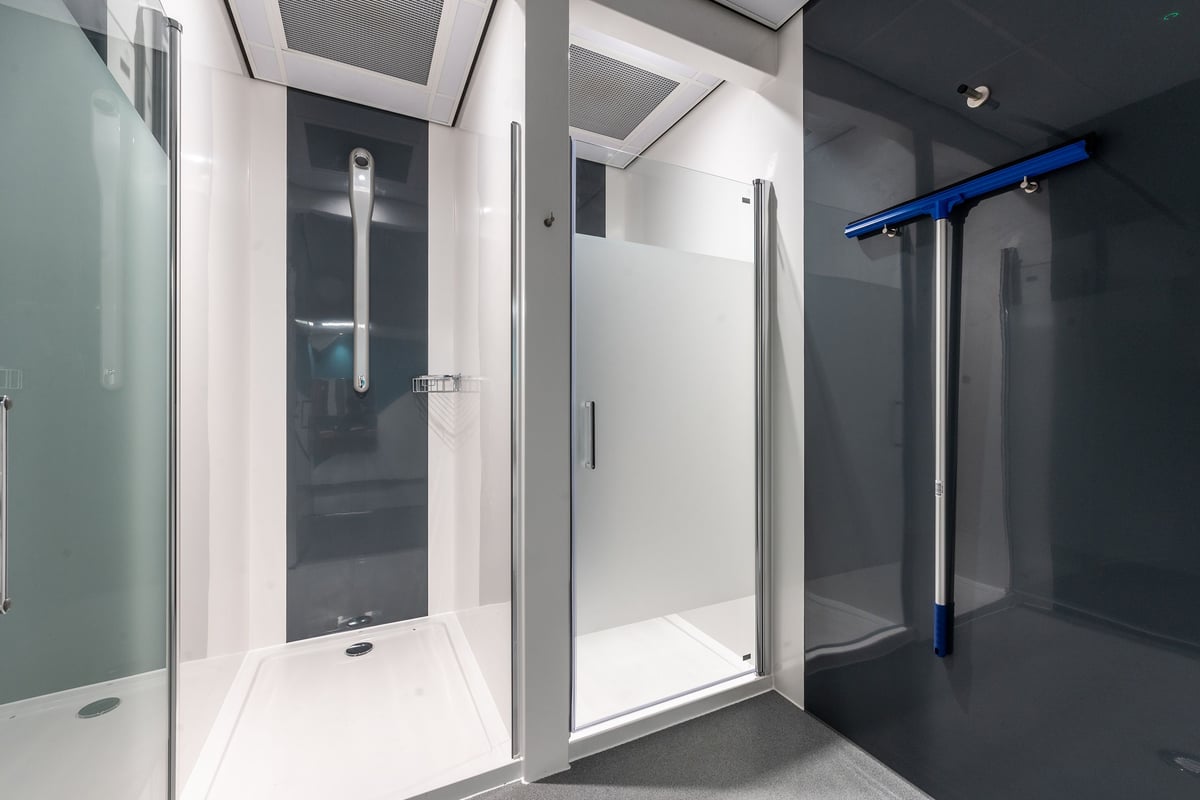 PureGym Coalville: Shower cubicles with glass doors, tiled walls and floors.