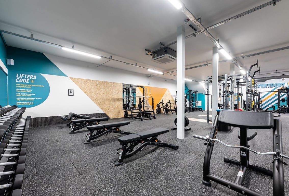 PureGym Heanor: Weight benches, resistance machines, free weights, and rubberized flooring inside a gym.