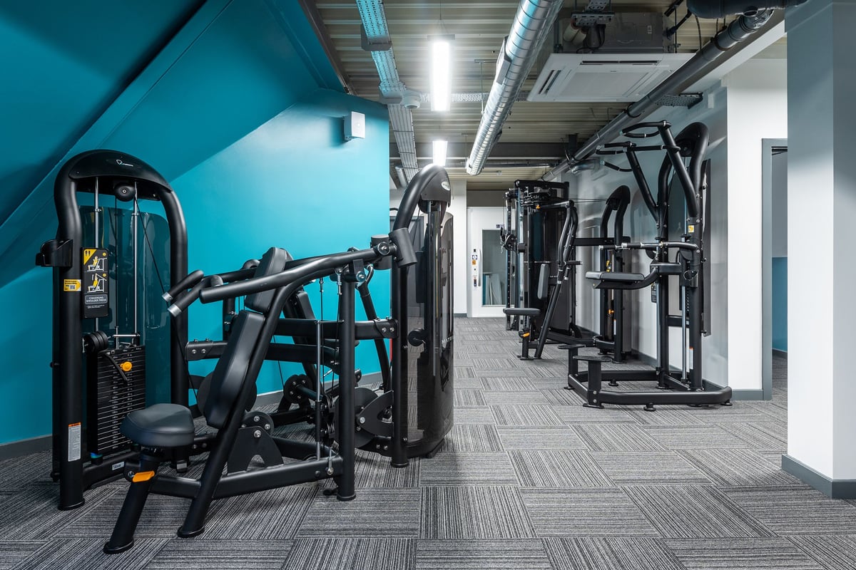 PureGym Brentwood: Resistance machines, weightlifting stations, patterned flooring in a gym studio.