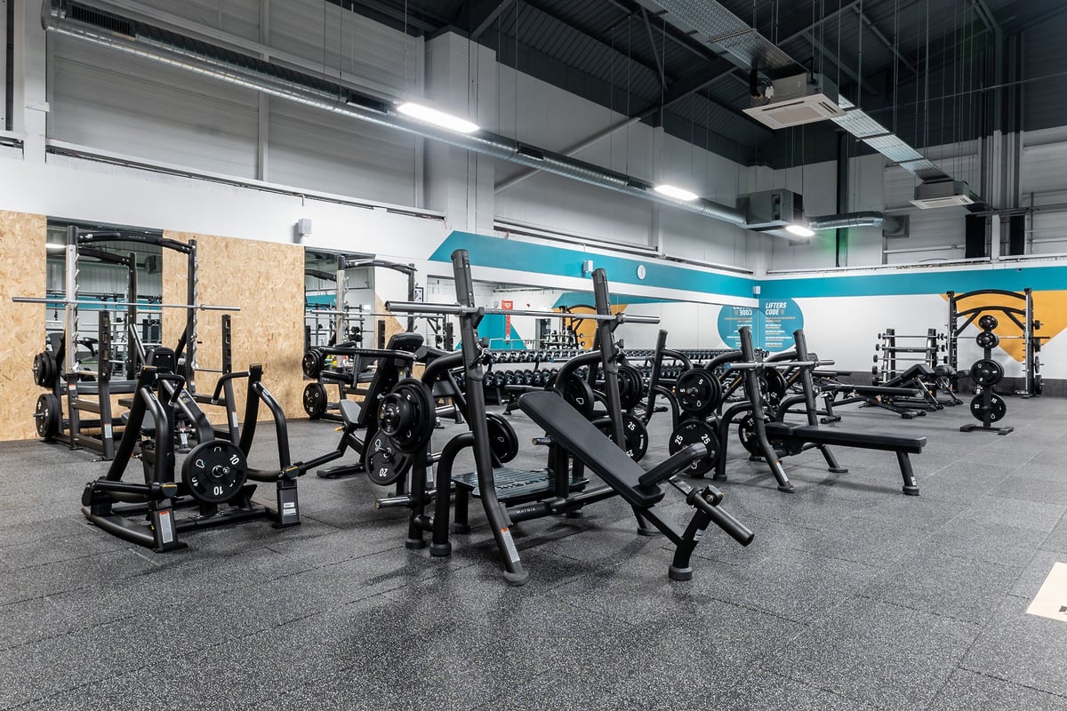 PureGym Sheffield Meadowhall Retail Park: Rows of weight machines, benches, and squat racks with rubberized flooring.