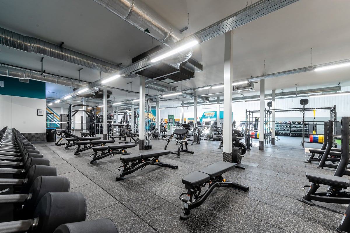 PureGym Grantham Discovery Retail Park: Gym with weights, benches, squat racks, rubberized floors, and exercise equipment.