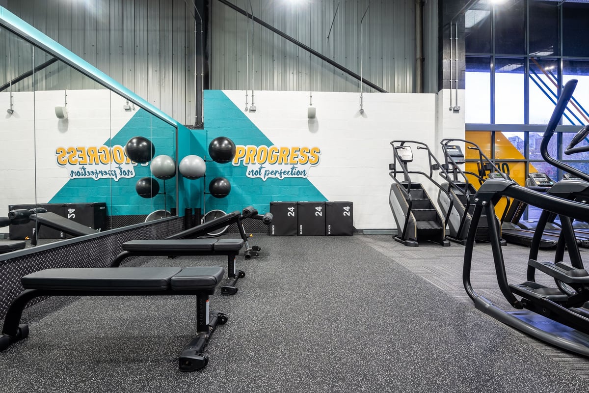 PureGym Dunfermline: Resistance machines with weighted sleds, benches, and rubberised flooring in a gym studio.