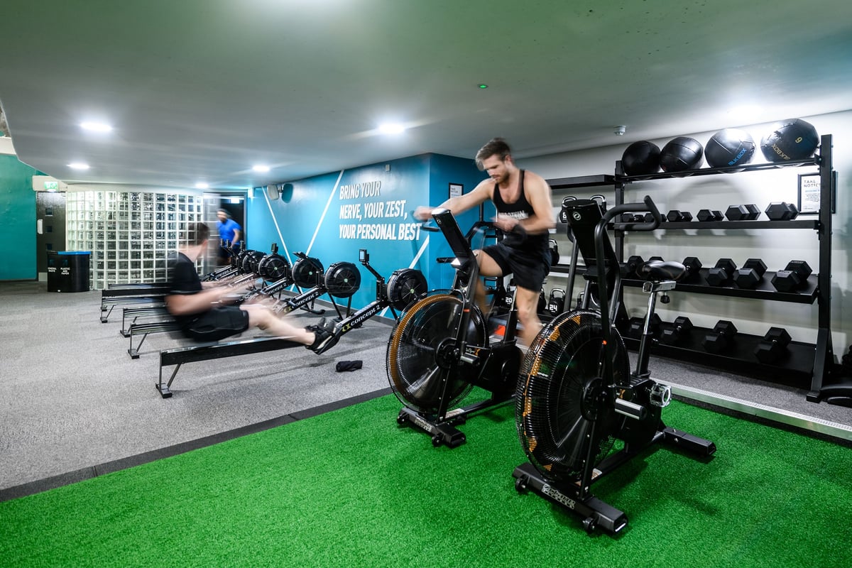 PureGym London St Pauls: Spin bikes, free weights, weight racks, turf area in gym studio interior.