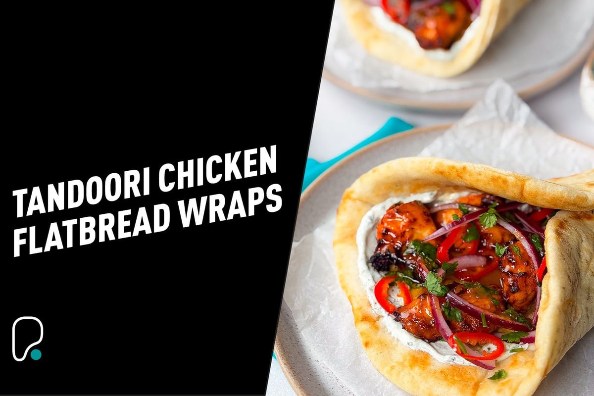 Tandoori chicken with red onions, chillies, and herbs in flatbread wraps on plates