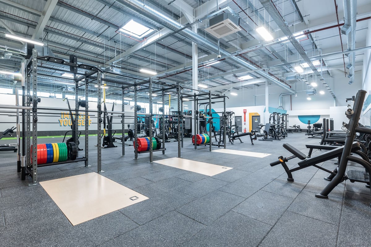 PureGym Nottingham Colwick: Strength training racks, weight plates, benches, rubberized flooring in an industrial-style gym.