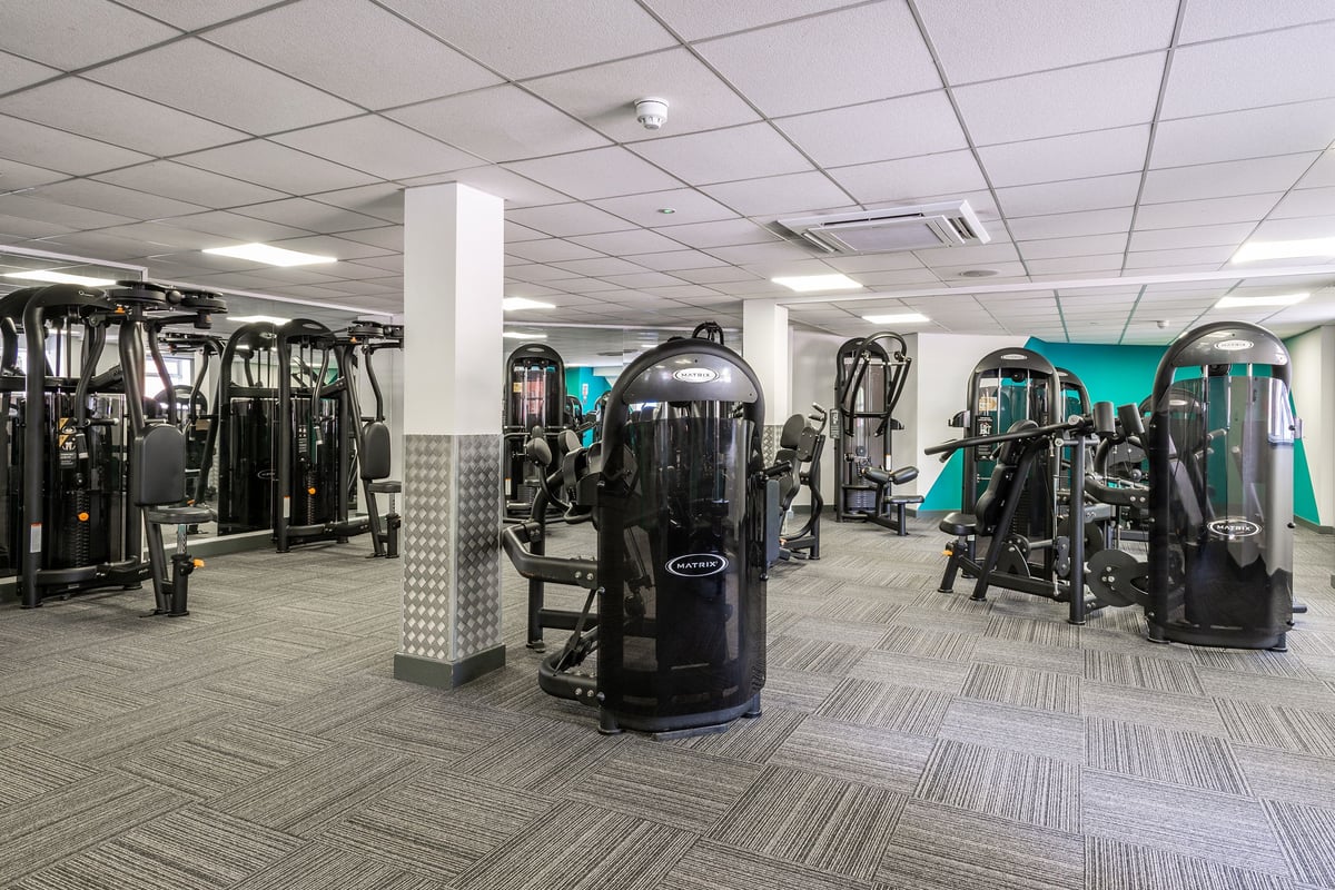 PureGym Northwich: Resistance machines, cable crossovers, weight racks, rubberized flooring in a gym setting.