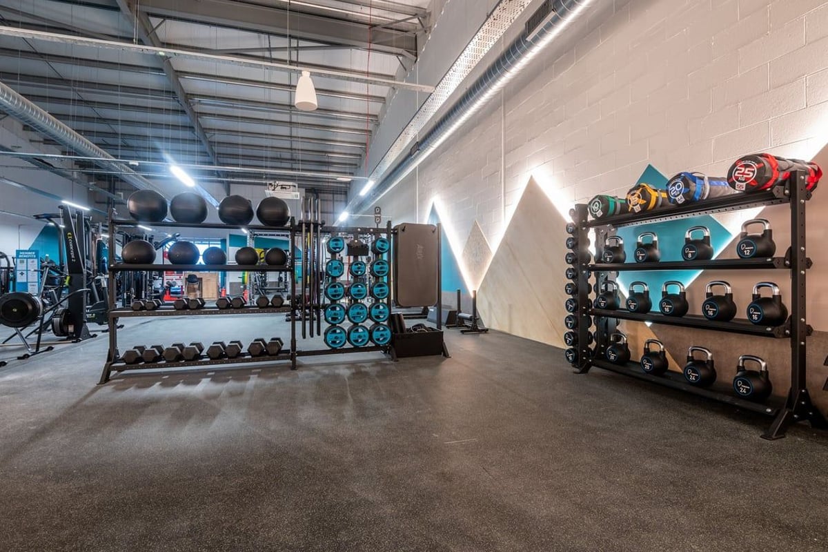PureGym Lanark: Rows of kettlebells, medicine balls, resistance bands and weight racks in a gym facility.