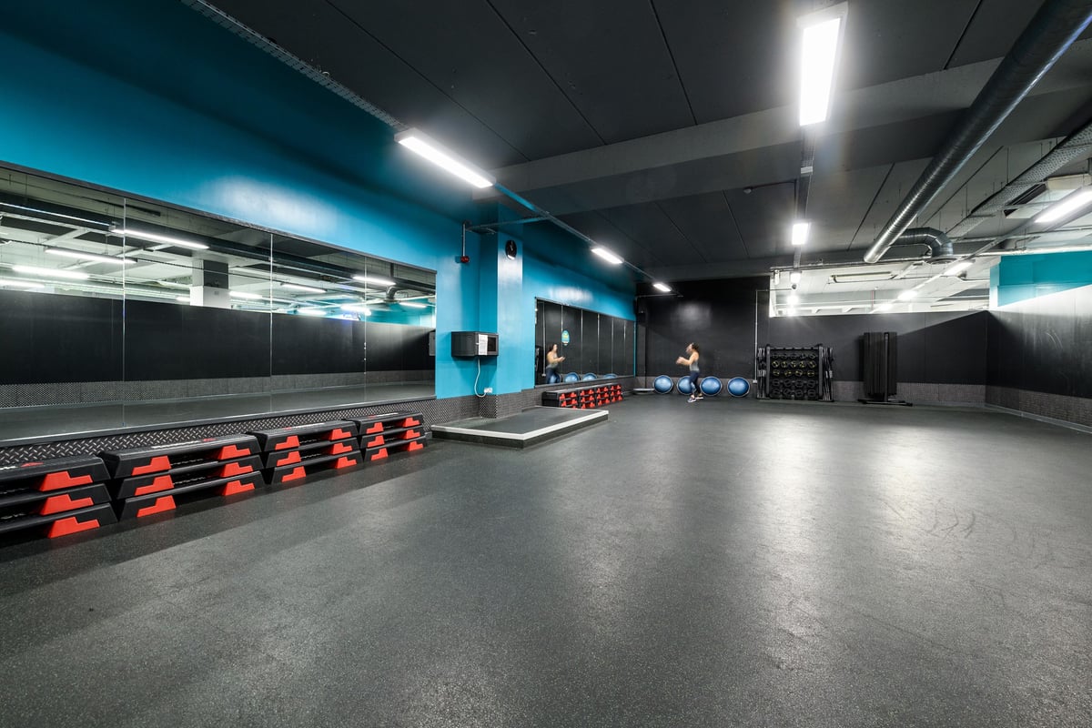 PureGym Bournemouth The Triangle: Rows of bright red weight benches, mirrored walls, and industrial-style lighting.