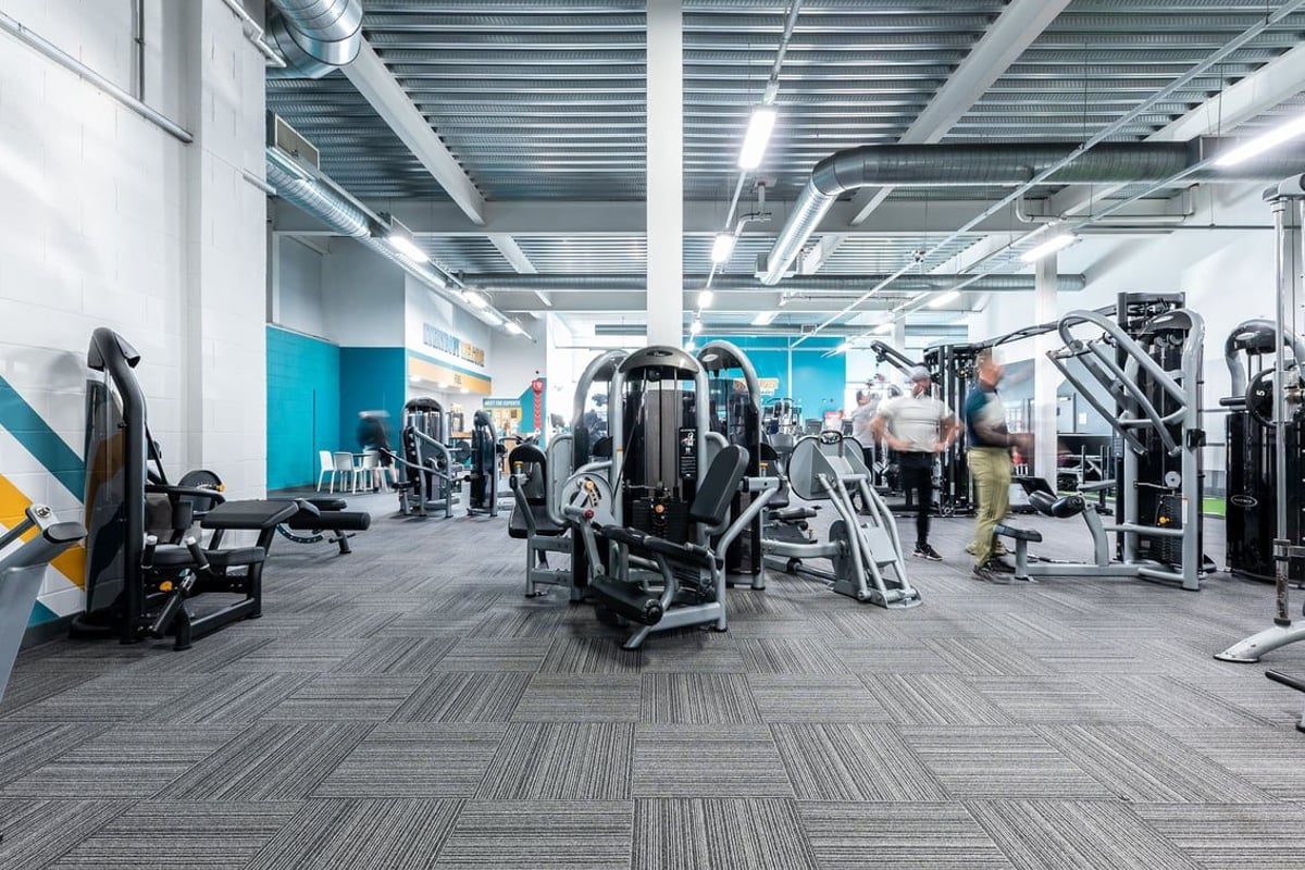 PureGym Hednesford Cannock: Rows of exercise machines, weight racks, benches, and rubberized flooring in a contemporary gym.