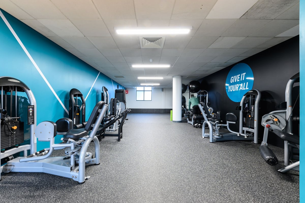 PureGym Norwich Riverside: Rows of weight machines, exercise bikes, and multicolour resistance bands.