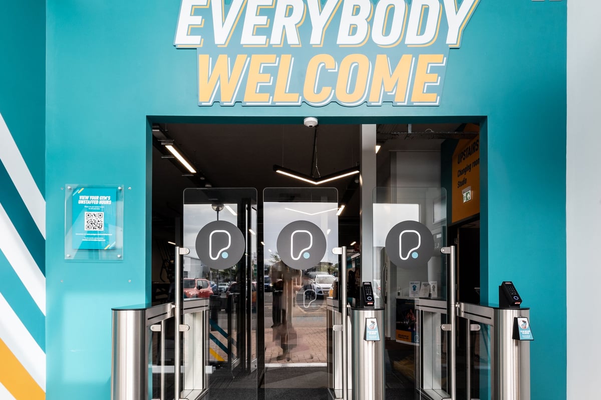 PureGym Sittingbourne: Gym entrance showing turnstiles and "Everybody Welcome" signage.