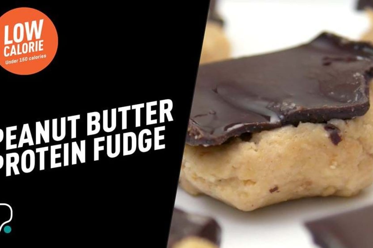 Peanut butter protein fudge squares topped with dark chocolate on a white plate