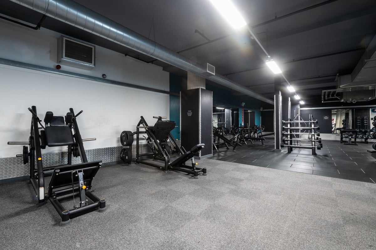 PureGym Liverpool Central: Rows of weight machines, benches, and free weights on rubberized gym flooring.