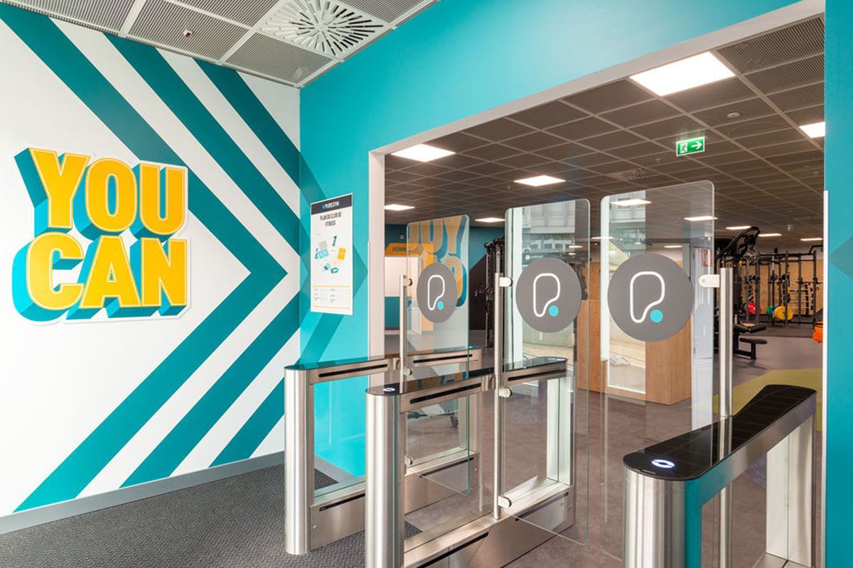 PureGym Lausanne Prilly: Entry gates with YOU CAN wall art.