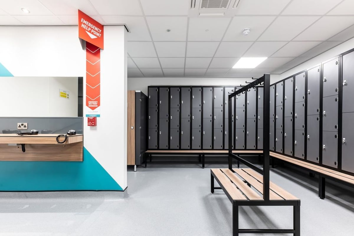 PureGym Yate: Lockers, benches, rubberized flooring in a gym changing area.