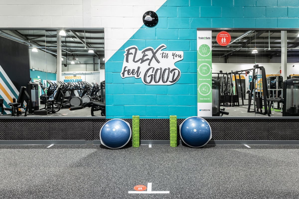 PureGym Swindon Stratton: Gym studio with weight racks, exercise balls, resistance bands, and motivational wall graphics.