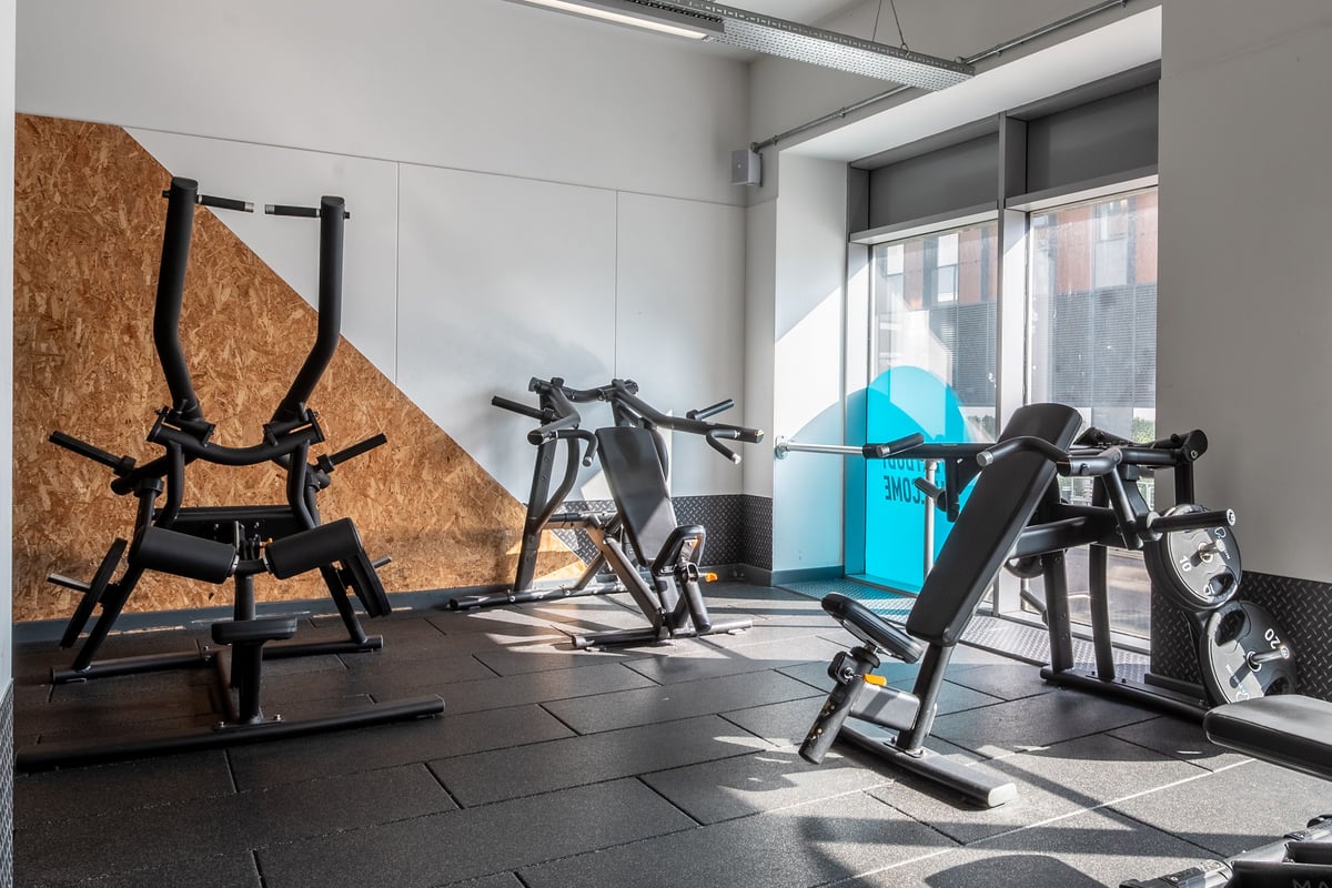 PureGym Stevenage: Resistance machines, exercise bikes, weight benches, rubberized flooring in a gym studio.