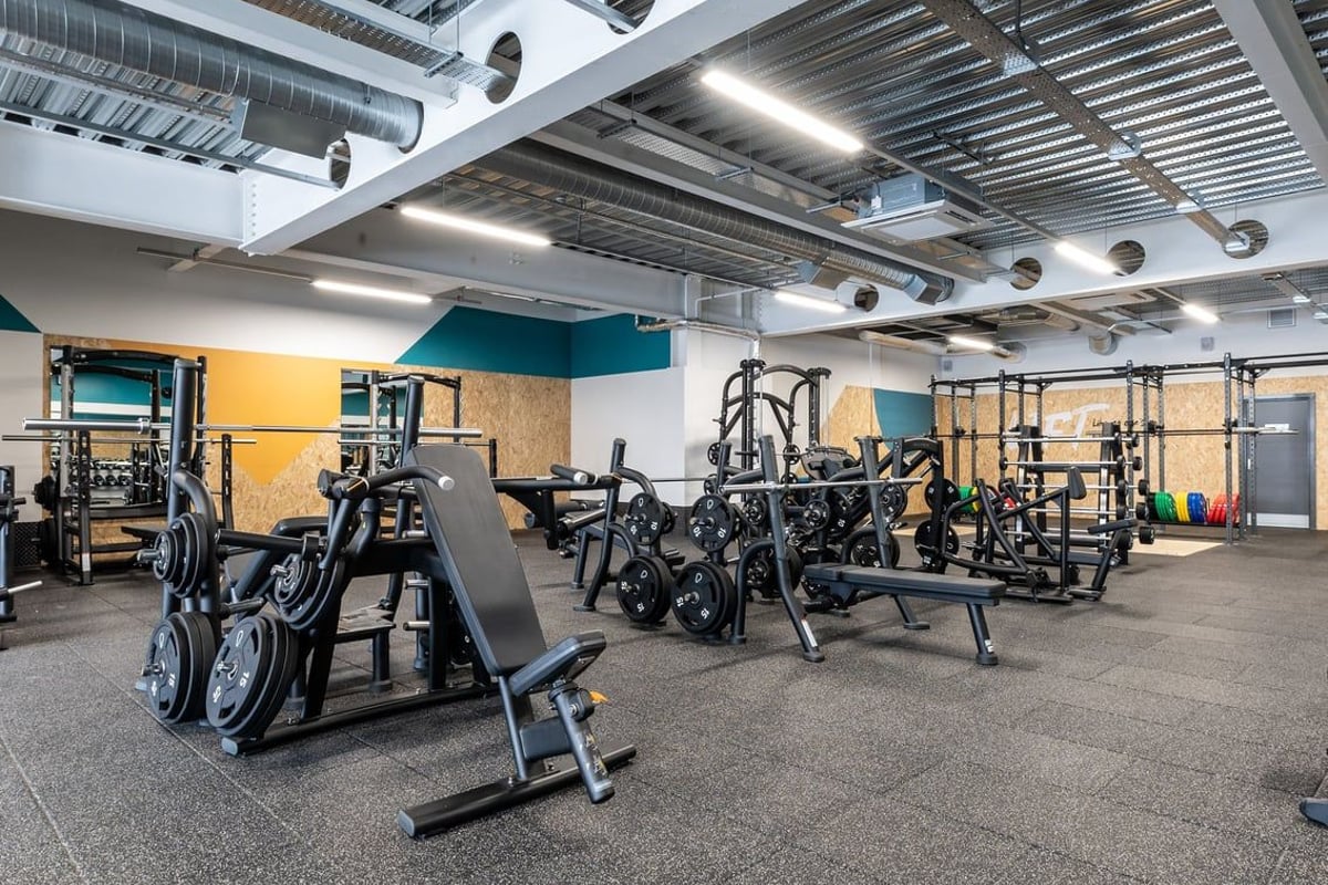 PureGym Yate: Strength training area with squat racks, weight machines, free weights, and rubberized flooring.