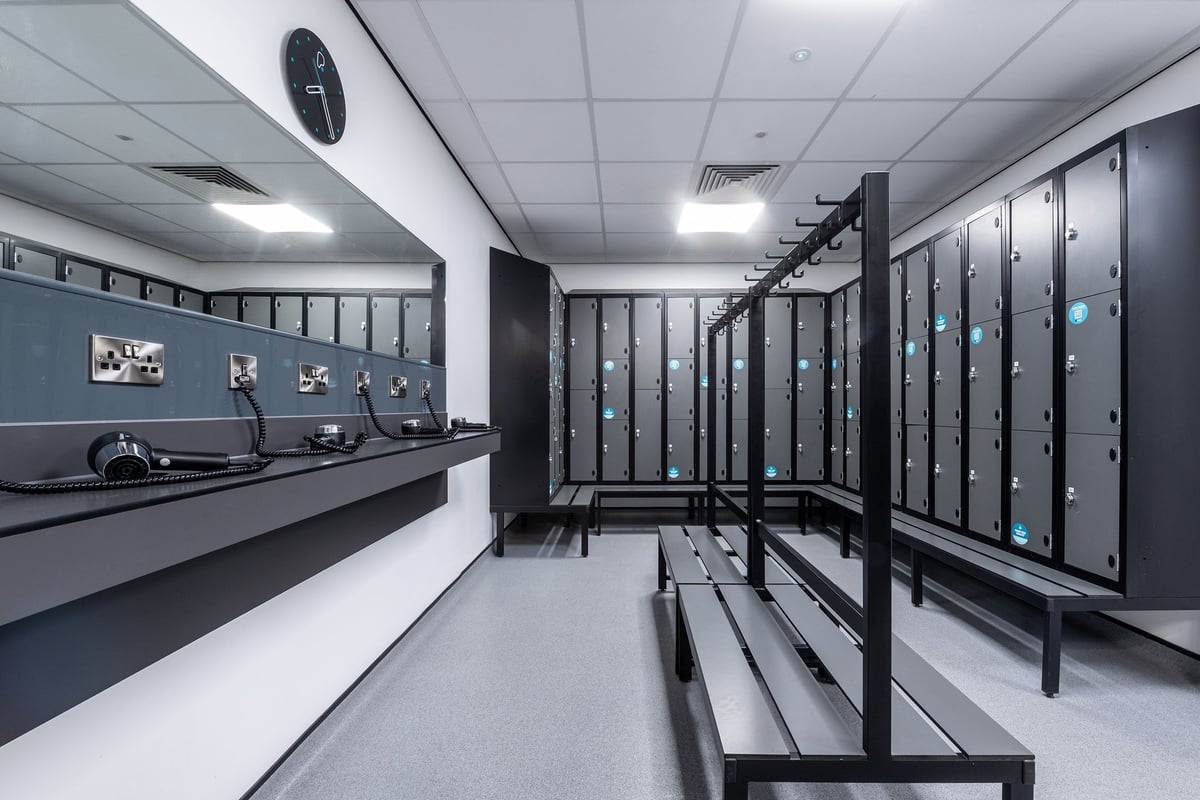 PureGym Weston-super-mare: Locker room light walls, lockers of various sizes, benches, hooks, mirrors, and hair dryers.