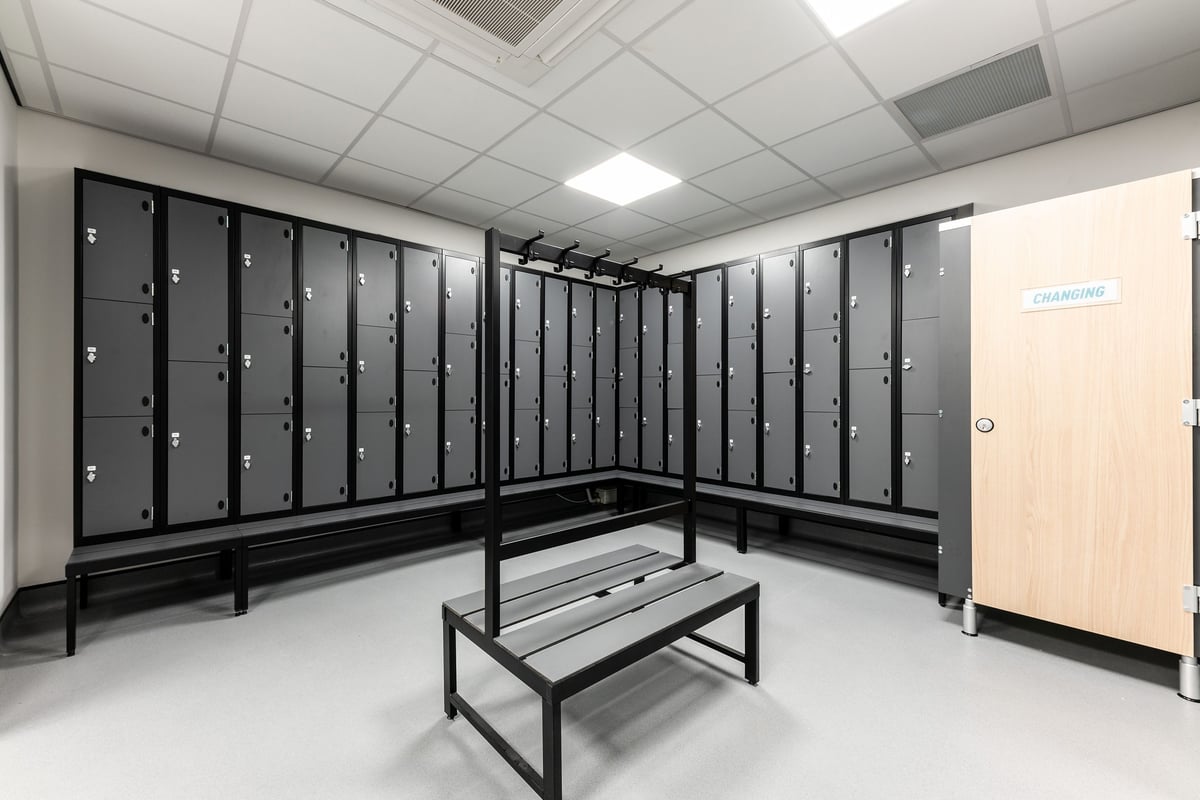 PureGym Kirkby: Rows of lockers, benches in a minimalist changing room interior.