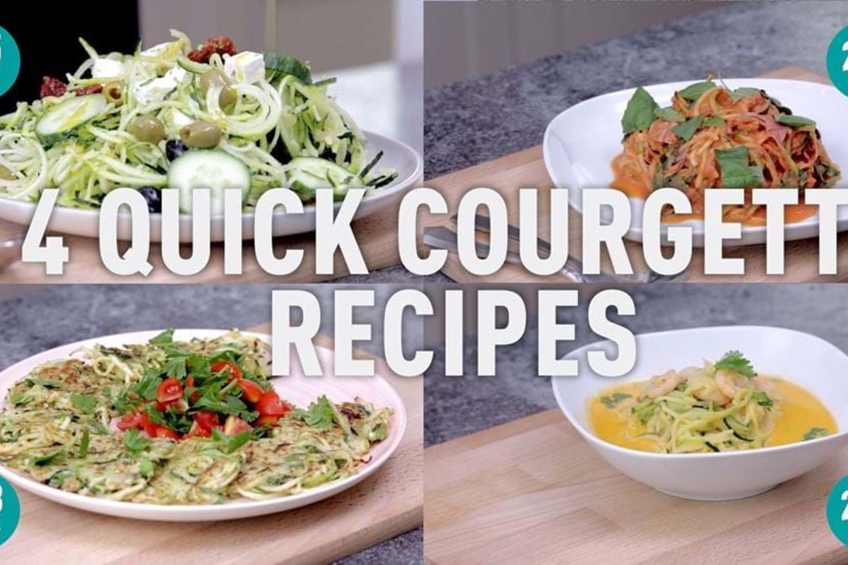 Four white plates of spiralised courgette dishes on grey kitchen worktop