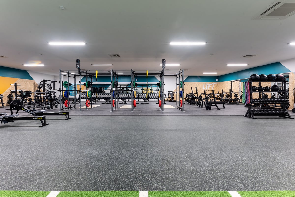 PureGym Selby: Squat racks, weights racks, barbells, weight plates, and rubberized flooring in a modern gym setting.