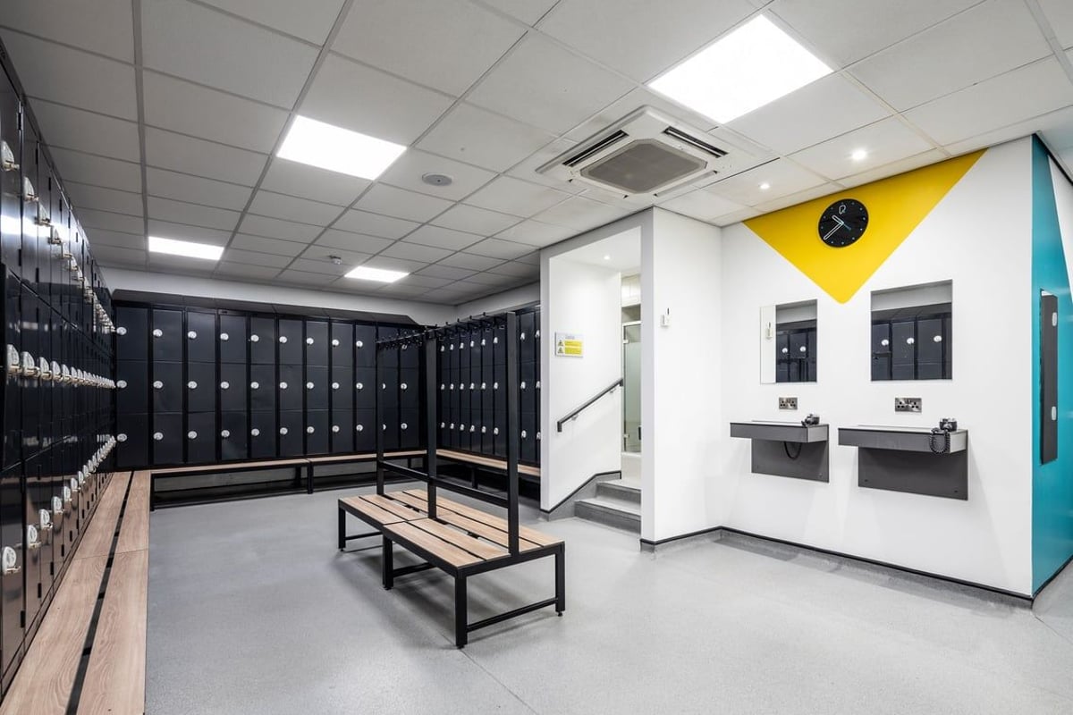 PureGym Cardiff Gate: Rows of lockers, benches, and cubby holes in a changing room setting.