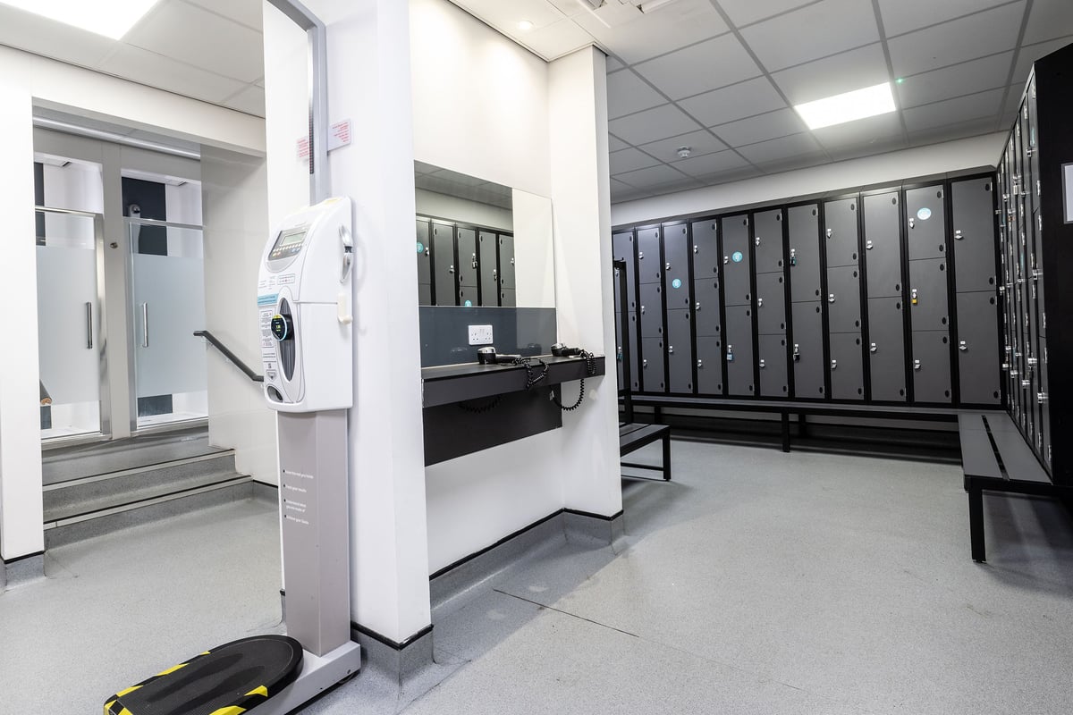 PureGym Manchester Cheetham Hill Retail Park: Lockers, fitness machine, benches in a gym changing room.