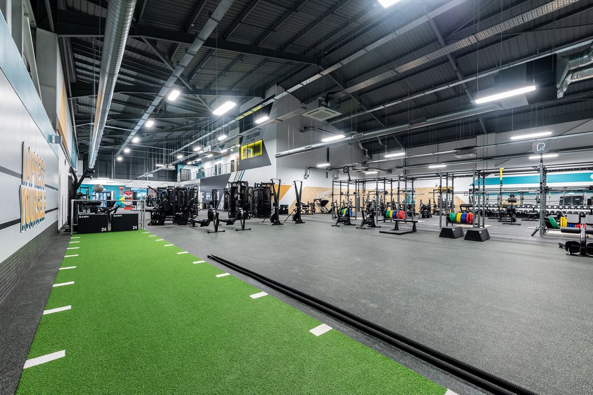PureGym Sheffield Meadowhall Retail Park: Racks of weights, benches, turf area, and ceiling-mounted lighting in a gym space.