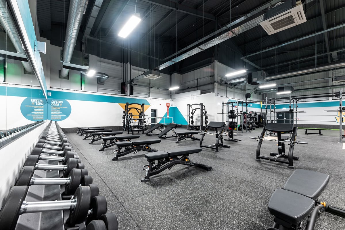 PureGym Sheffield Meadowhall Retail Park: Weightlifting area with benches, squat racks, free weights, and rubberized floors.