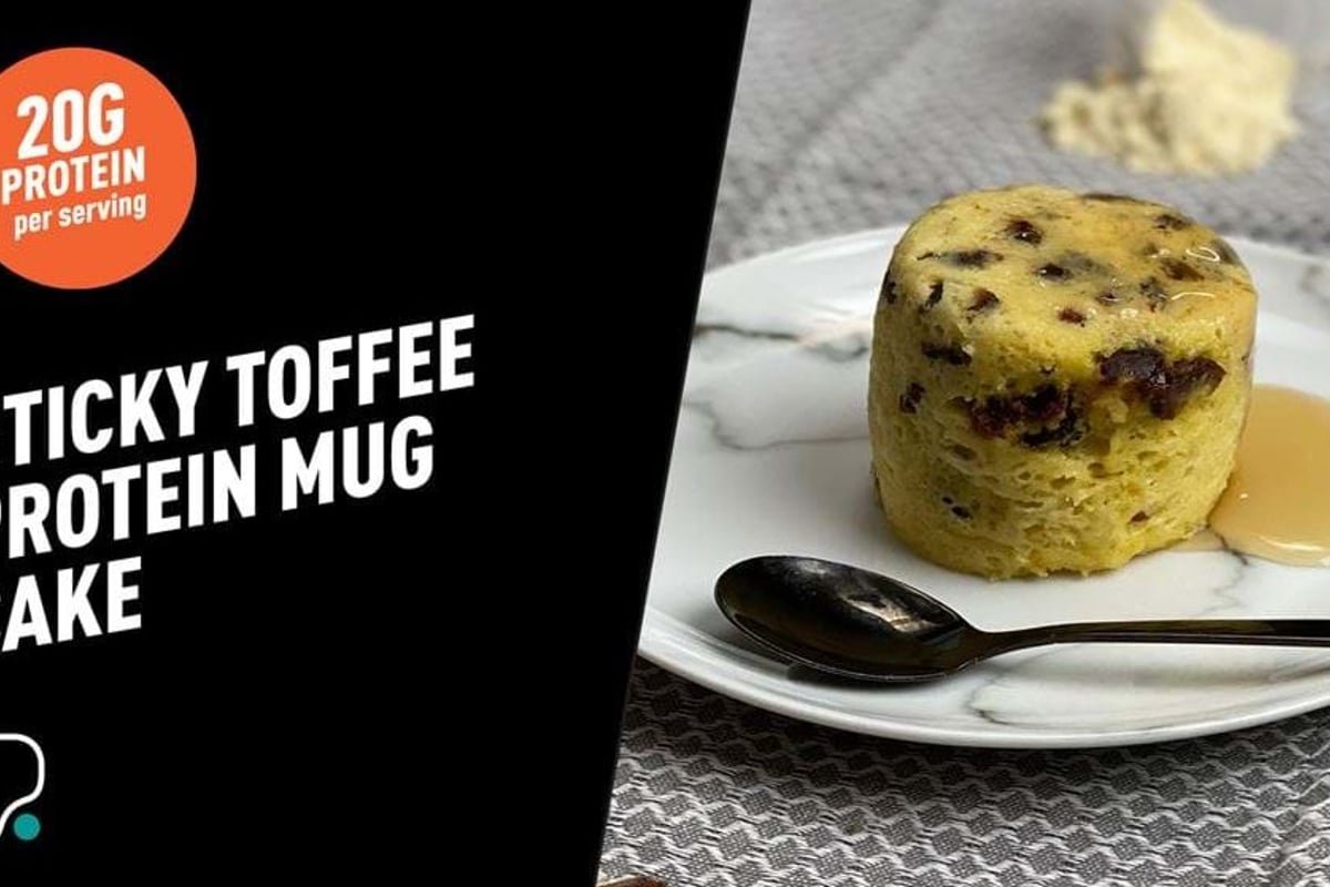 Golden sponge cake with chocolate chips and toffee sauce on a white plate with a spoon