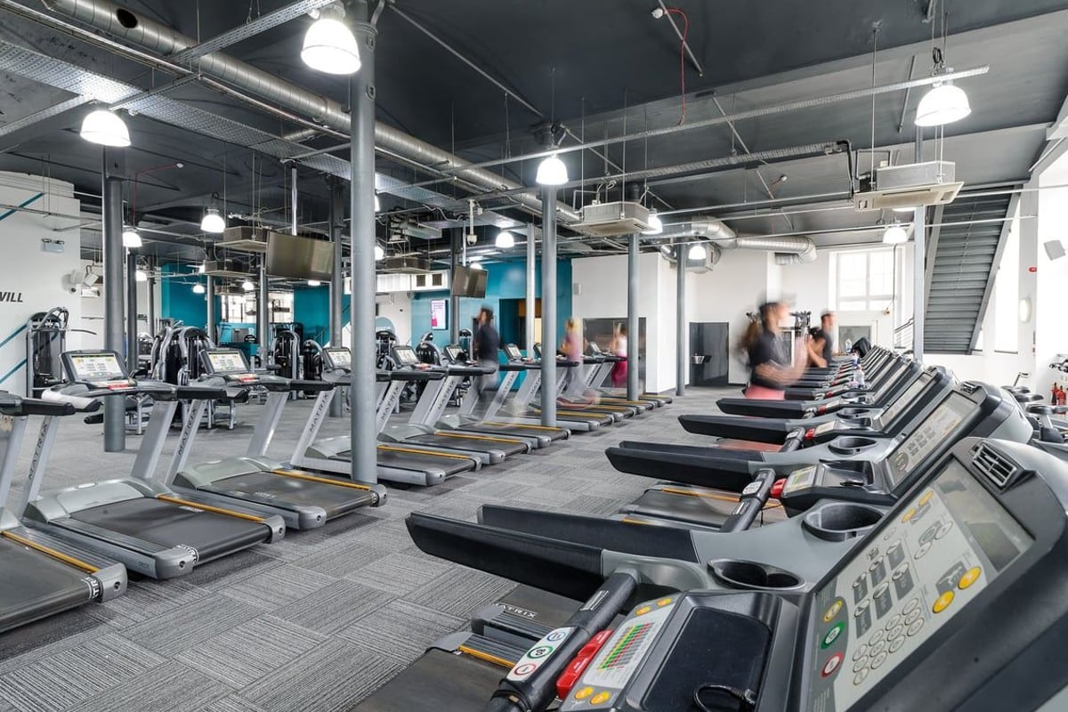 PureGym Dundee: Rows of treadmills, ellipticals, and other cardio machines in a modern gym setting.