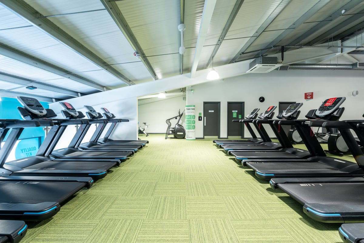 PureGym Plymouth Marsh Mills: Rows of treadmills and other cardio machines in a gym's exercise area.