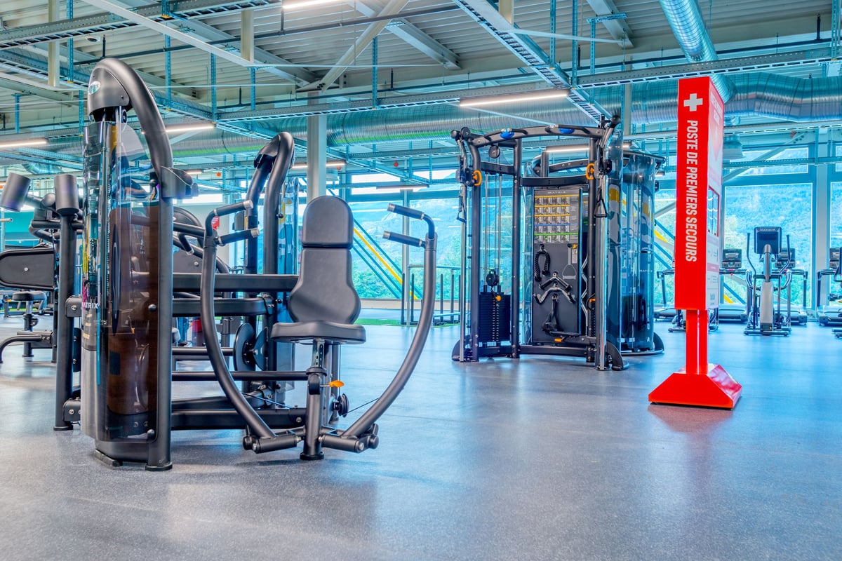 PureGym Martigny: Kraftgeräte, Kabelübergangsstationen und Hantelständer.