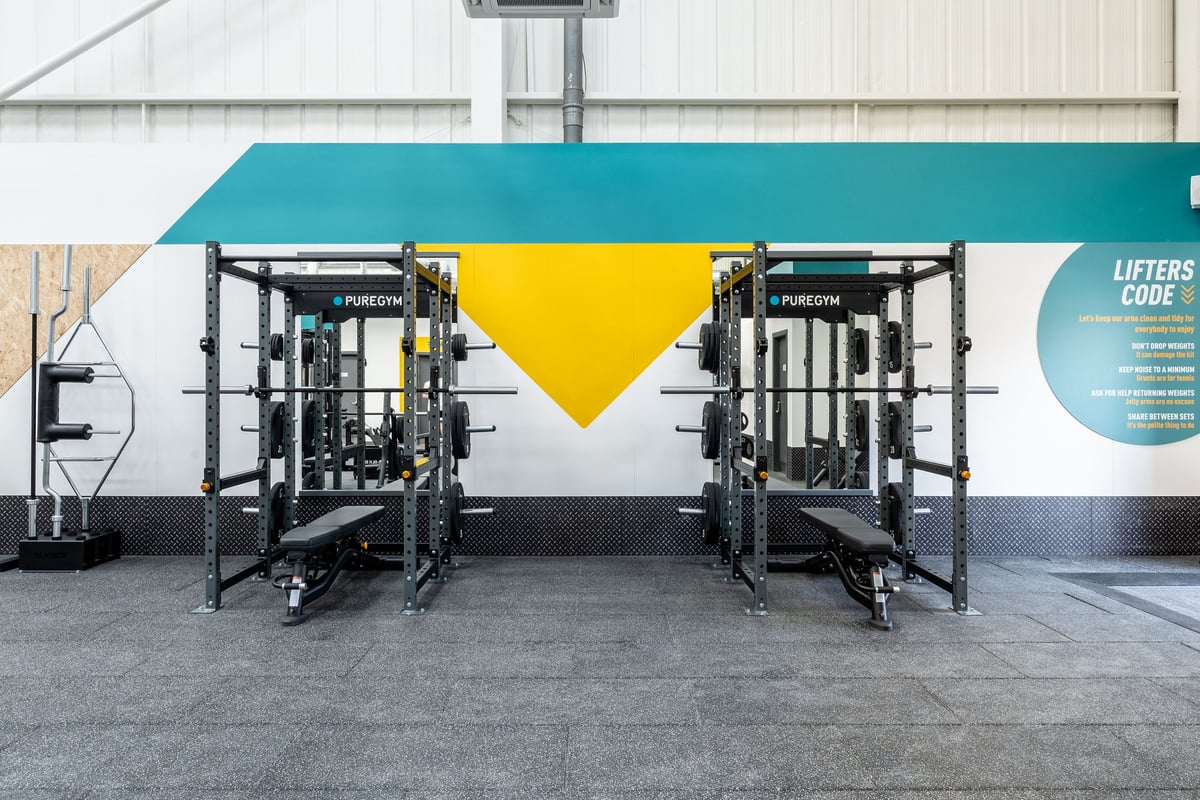 PureGym Keighley: Rows of wheeled weightlifting platforms with upright support bars.