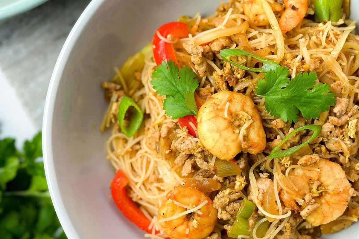 Rice noodles with prawns, minced meat, red peppers, spring onions, and coriander leaves in